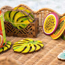 Load image into Gallery viewer, Fruit-themed coasters on a woven surface with a wooden crate.