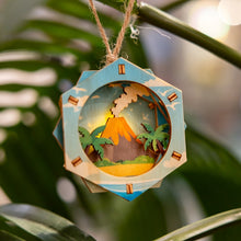 Load image into Gallery viewer, Decorative 3D ornament with a tropical volcano scene hanging on a branch

