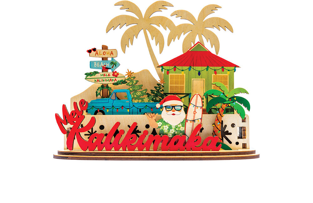 Decorative 3D holiday tiered sign with Santa holding a surfboard, a blue truck, beach shack and other tropical elements with 'Mele Kalikimaka' script on a white background