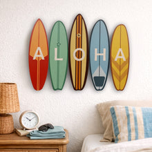 Load image into Gallery viewer, Five colorful surfboard-shaped signs spelling 'ALOHA' on a wall above a bed.
