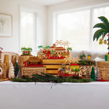Load image into Gallery viewer, Decorative table setup with palm trees, baskets, and small figurines in a room with large windows.
