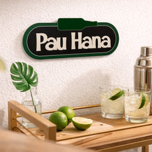 Load image into Gallery viewer, Bar cart with cocktails, limes, and a 'Pau Hana' sign on a textured wall.
