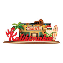 Load image into Gallery viewer, Decorative 3D holiday sign with &#39;Holly Jolly Ukuleles&#39; shop and a Shaka Santa Claus figure holding a surfboard next to a palm tree on a white background.
