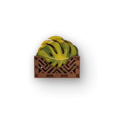 Decorative coaster set with a leaf design in a wooden coaster holder on a white background