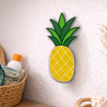 Load image into Gallery viewer, Wooden pineapple decoration on a textured wall with a basket and towel in the background.
