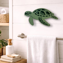 Load image into Gallery viewer, Green turtle wall decor in a bathroom setting with towels and plants.
